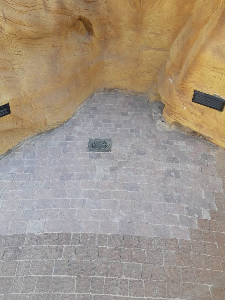 ריצוף אבן טבעית בחצר עם קולטן ניקוז ושיפוע מתוכנן
