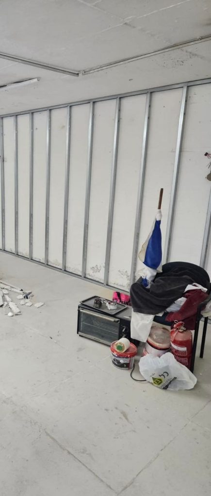 שלד פרופילי מתכת מותקן לאורך קיר לקראת חיפוי בלוחות גבס